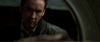 Movie still from “Identity” (2003), directed by James Mangold – A person wearing a suit and tie; Close Up shot, Low angle