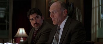 Movie still from “Identity” (2003), directed by James Mangold – Two men in business suits sitting next to each other; Close Up shot, Low angle