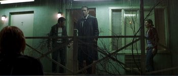 Movie still from “Identity” (2003), directed by James Mangold – A man and a woman standing in front of a house; Wide shot, Low angle