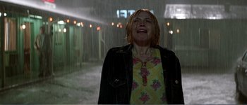 Movie still from “Identity” (2003), directed by James Mangold – A woman is crying while standing in the rain; Medium shot, Low angle