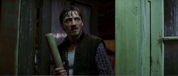 Movie still from “Identity” (2003), directed by James Mangold – A man holding a baseball bat while standing next to a wall; Close Up shot, Low angle