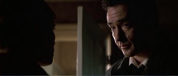 Movie still from “Identity” (2003), directed by James Mangold – A man standing next to another man in front of a mirror; Close Up shot, Over the shoulder angle