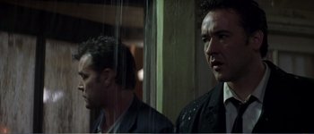Movie still from “Identity” (2003), directed by James Mangold – A man in a suit and tie next to another man in a suit and tie; Close Up shot, Low angle