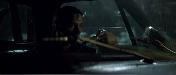 Movie still from “Identity” (2003), directed by James Mangold – A man in a car holding a wooden stick; Close Up shot, Low angle