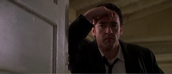 Movie still from “Identity” (2003), directed by James Mangold – A person wearing a suit and tie; Close Up shot, Low angle