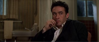 Movie still from “Identity” (2003), directed by James Mangold – A person wearing a suit and tie; Close Up shot, Low angle