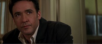 Movie still from “Identity” (2003), directed by James Mangold – A person wearing a suit and tie; Close Up shot, Low angle