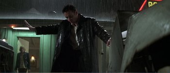 Movie still from “Identity” (2003), directed by James Mangold – A man standing in the pouring rain with his arms outstreched; Medium shot, Low angle