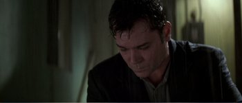 Movie still from “Identity” (2003), directed by James Mangold – A person wearing a suit and tie; Close Up shot, Low angle