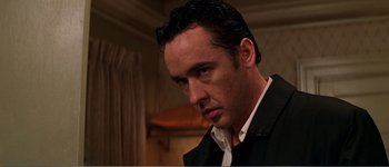 Movie still from “Identity” (2003), directed by James Mangold – A person wearing a suit and tie; Close Up shot, Low angle