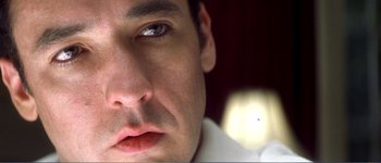 Movie still from “Identity” (2003), directed by James Mangold – A man's face with a white background; Extreme Close Up shot, Low angle