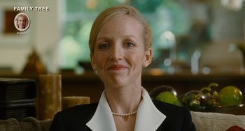 Movie still from “Idiocracy” (2006), directed by Mike Judge – A person wearing a suit and a necklace; Close Up shot, Over the shoulder angle