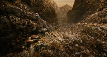 Movie still from “Idiocracy” (2006), directed by Mike Judge – A pile of garbage in a rocky area with mountains in the background; Extreme Wide shot, Overhead angle