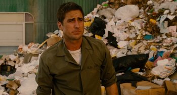 Movie still from “Idiocracy” (2006), directed by Mike Judge – A person standing in front of a pile of trash; Close Up shot, High angle
