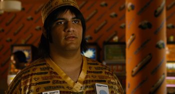 Movie still from “Idiocracy” (2006), directed by Mike Judge – A man wearing a yellow shirt and a yellow hat; Close Up shot, Over the shoulder angle