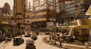 Movie still from “Idiocracy” (2006), directed by Mike Judge – People are standing in the middle of a busy city street; Extreme Wide shot, High angle