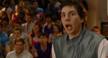 Movie still from “Idiocracy” (2006), directed by Mike Judge – A man standing in front of a crowd of onlookers with his mouth open; Close Up shot, Over the shoulder angle