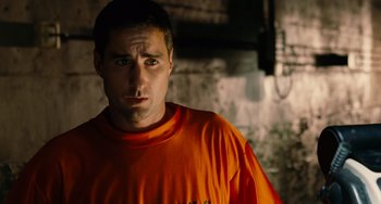 Movie still from “Idiocracy” (2006), directed by Mike Judge – A person wearing an orange t - shirt; Close Up shot, Over the shoulder angle