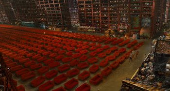 Movie still from “Idiocracy” (2006), directed by Mike Judge – A room filled with lots of red couches and chairs; Extreme Wide shot, High angle