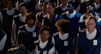 Movie still from “Idiocracy” (2006), directed by Mike Judge – A group of men standing next to each other; Medium shot, Over the shoulder angle