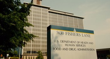 Movie still from “Idiocracy” (2006), directed by Mike Judge – A large sign in front of a large building; Extreme Wide shot, Low angle