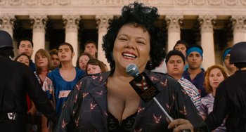 Movie still from “Idiocracy” (2006), directed by Mike Judge – A woman is speaking in front of a group of people; Close Up shot, Low angle