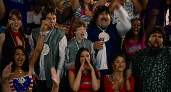 Movie still from “Idiocracy” (2006), directed by Mike Judge – A group of people sitting and standing in front of a crowd; Medium shot, High angle