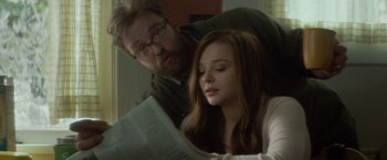 Movie still from “If I Stay” (2014), directed by R.J. Cutler – A man and a woman reading a newspaper together; Close Up shot, Over the shoulder angle