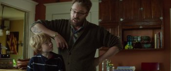 Movie still from “If I Stay” (2014), directed by R.J. Cutler – A man with a beard and glasses is standing in a kitchen; Medium shot, Over the shoulder angle