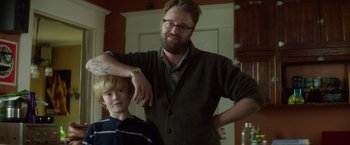 Movie still from “If I Stay” (2014), directed by R.J. Cutler – A man standing next to a boy in a room; Medium shot, Over the shoulder angle