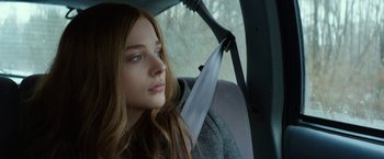 Movie still from “If I Stay” (2014), directed by R.J. Cutler – A woman sitting in the back seat of a car; Close Up shot, Over the shoulder angle