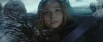 Movie still from “If I Stay” (2014), directed by R.J. Cutler – A woman sitting in the back seat of a car looking out the window; Close Up shot, Low angle