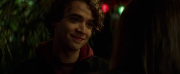 Movie still from “If I Stay” (2014), directed by R.J. Cutler – A man with curly blonde hair sitting at a table; Close Up shot, Over the shoulder angle