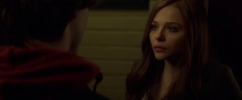 Movie still from “If I Stay” (2014), directed by R.J. Cutler – A young woman looking at a young man in a dark room; Close Up shot, Over the shoulder angle