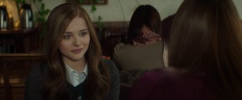 Movie still from “If I Stay” (2014), directed by R.J. Cutler – A woman sitting in front of two other women; Close Up shot, Over the shoulder angle