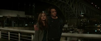 Movie still from “If I Stay” (2014), directed by R.J. Cutler – A man and a woman standing next to each other; Medium shot, Low angle
