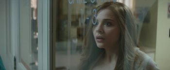 Movie still from “If I Stay” (2014), directed by R.J. Cutler – A woman looking out a window at a cake shop; Close Up shot, Over the shoulder angle
