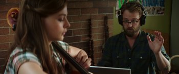 Movie still from “If I Stay” (2014), directed by R.J. Cutler – A man and a woman are playing a violin; Close Up shot, Over the shoulder angle