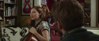 Movie still from “If I Stay” (2014), directed by R.J. Cutler – A woman holding a cello while a man looks on; Medium shot, Over the shoulder angle