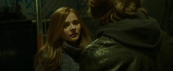 Movie still from “If I Stay” (2014), directed by R.J. Cutler – A woman with long red hair looking into a mirror; Close Up shot, Over the shoulder angle