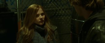Movie still from “If I Stay” (2014), directed by R.J. Cutler – A woman with long red hair standing in front of a fence; Close Up shot, Over the shoulder angle