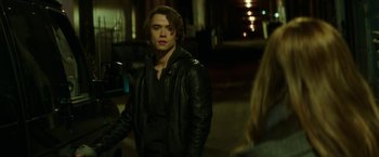 Movie still from “If I Stay” (2014), directed by R.J. Cutler – A man in a leather jacket standing next to a woman in a black jacket; Medium shot, Over the shoulder angle