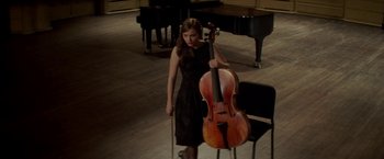 Movie still from “If I Stay” (2014), directed by R.J. Cutler – A woman in a black dress is holding a cello; Wide shot, High angle
