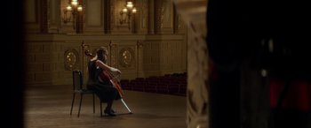 Movie still from “If I Stay” (2014), directed by R.J. Cutler – A woman sitting on a chair holding a violin; Extreme Wide shot, Over the shoulder angle