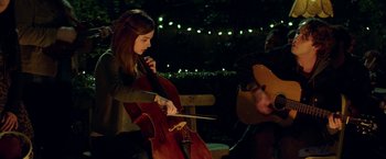 Movie still from “If I Stay” (2014), directed by R.J. Cutler – A woman playing the cello while a man plays the guitar; Medium shot, Over the shoulder angle