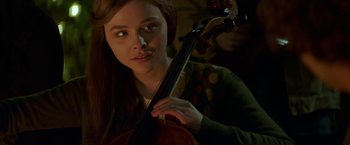 Movie still from “If I Stay” (2014), directed by R.J. Cutler – A woman is holding a violin in her hands; Close Up shot, Over the shoulder angle