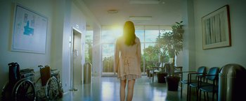 Movie still from “If I Stay” (2014), directed by R.J. Cutler – A woman is walking down the hallway of a building; Wide shot, Low angle