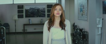 Movie still from “If I Stay” (2014), directed by R.J. Cutler – A woman with long red hair wearing a white top; Medium shot, Over the shoulder angle