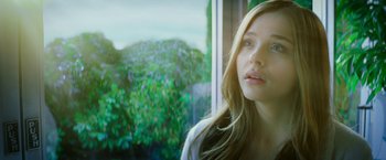Movie still from “If I Stay” (2014), directed by R.J. Cutler – A beautiful young woman looking out a window; Close Up shot, Low angle