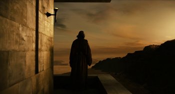 Movie still from “Immortals” (2011), directed by Tarsem Singh – A man standing on a ledge looking out at the sky; Wide shot, Low angle